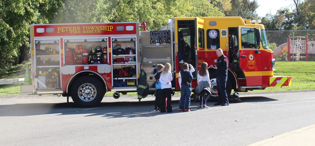 Students talking with a fireman.