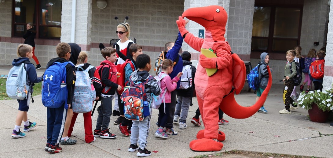 Student high-five the parents dressed as Buzzer Bee and Taco Dragon.