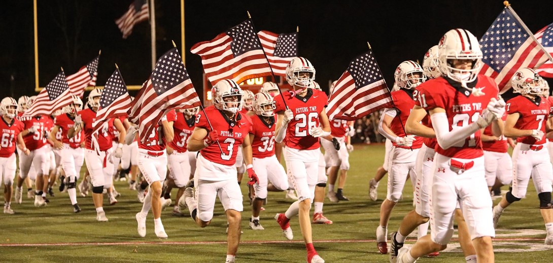 Football players on field with flags.