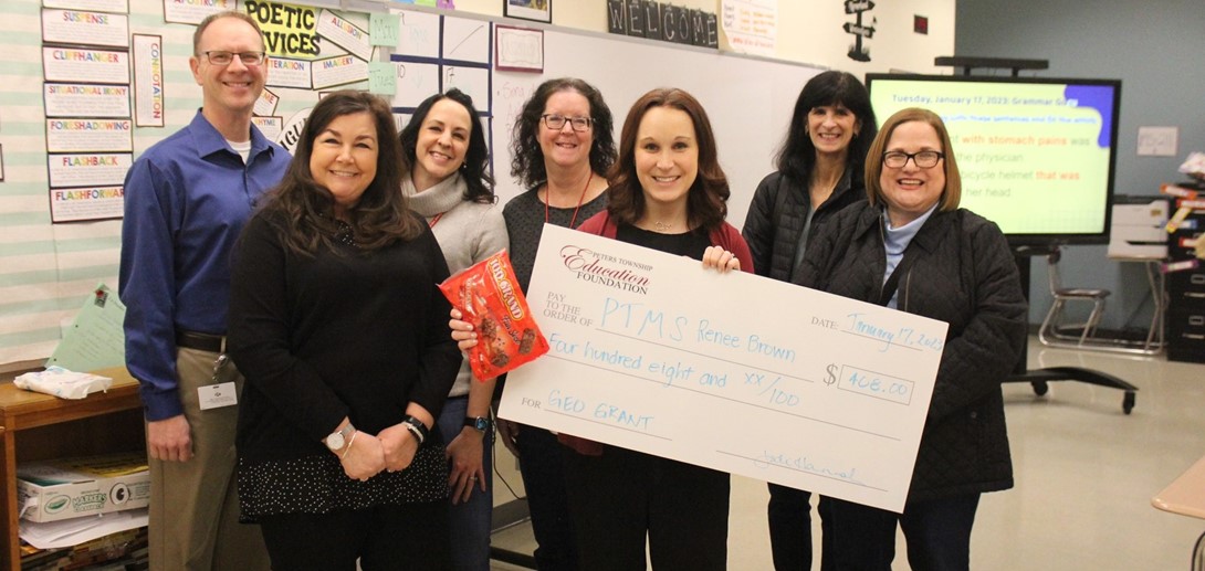 Foundation board members present a check to the winning teachers.