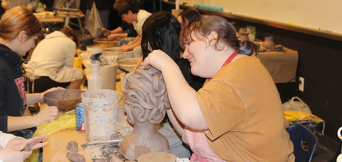 Students create their clay sculptures.