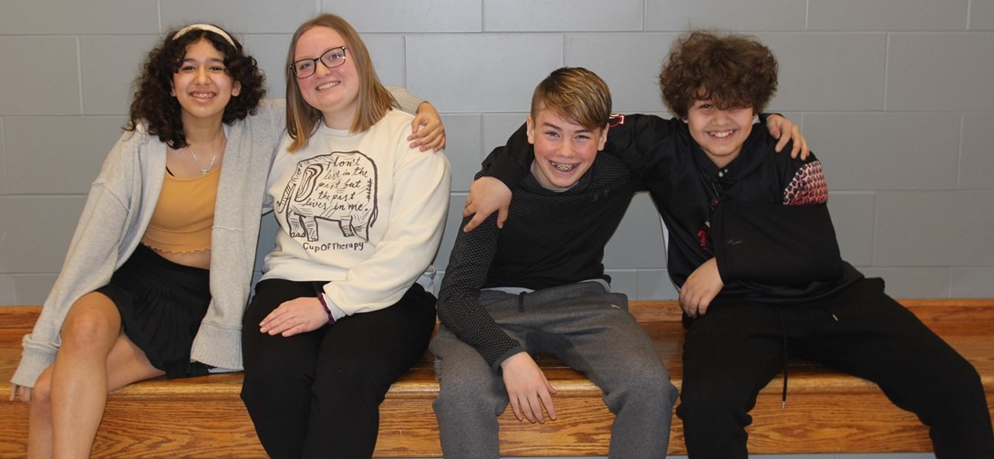 Students selected for the Choir smiling on the bench.