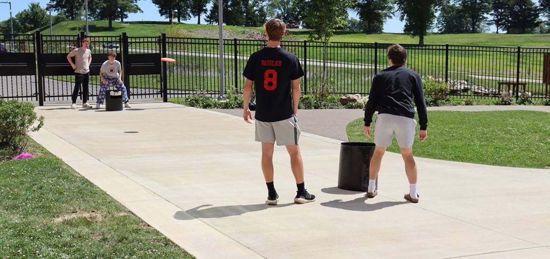 Students play frisbee during lunch outside.