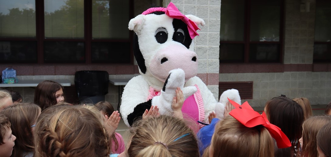 Students high-five Molly the cow.