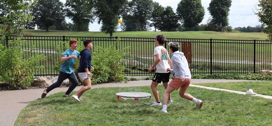 Students playing spikeball outside the cafeteria.
