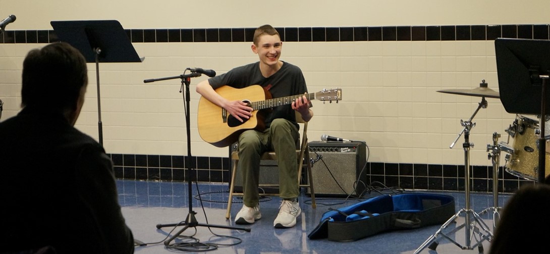 Student plays the guitar at the variety show.