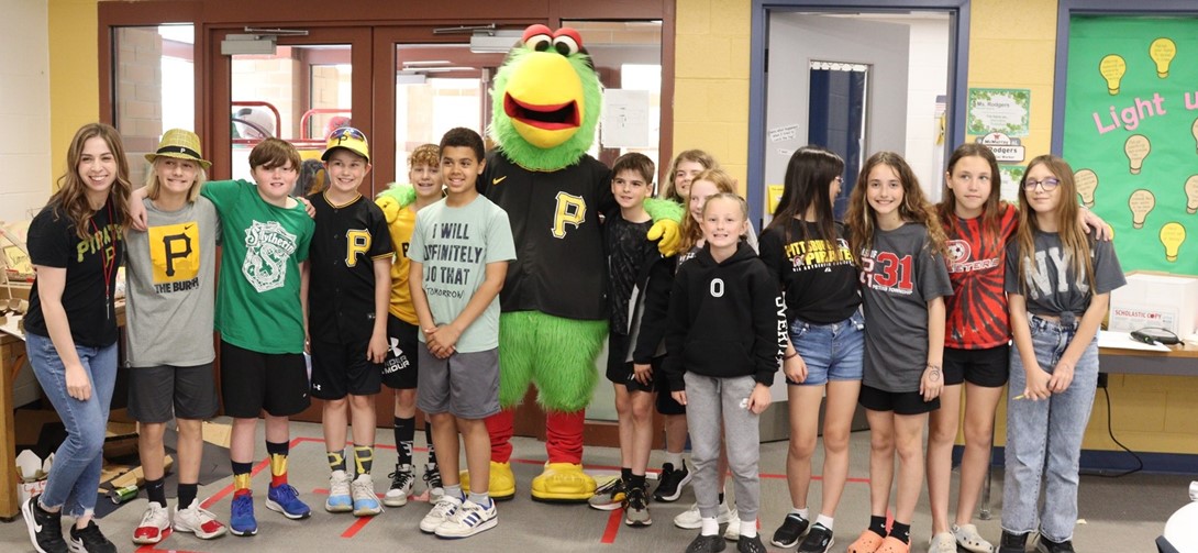 The Pirate Parrot poses with students dressed in black and gold.