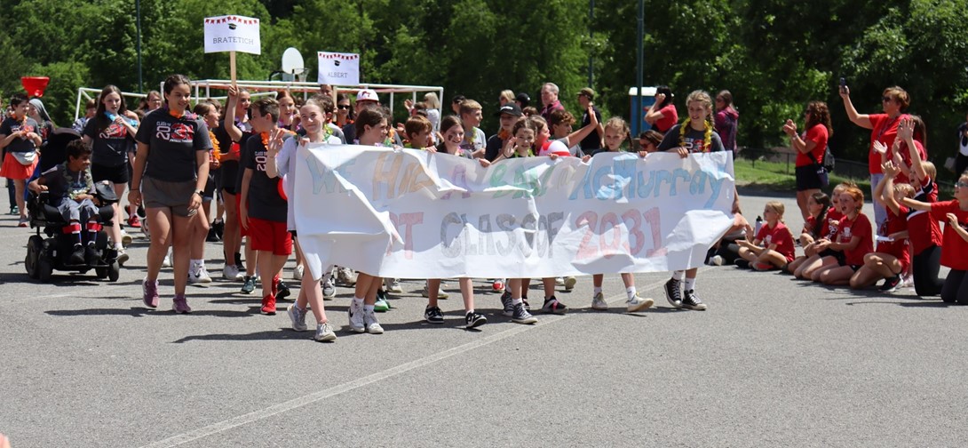 Students walk in a parade with a banner that says Class of 2031