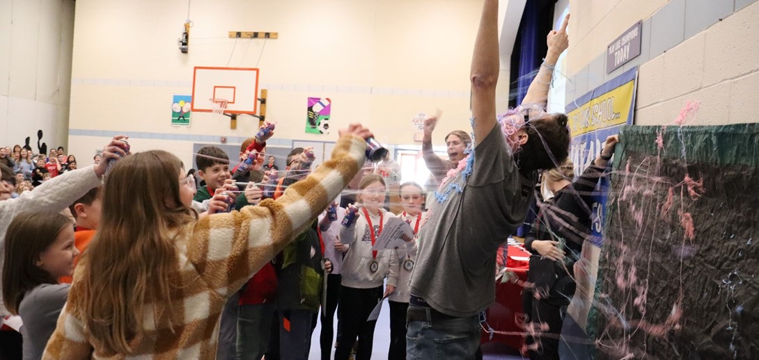 Students spray their principal with silly string.