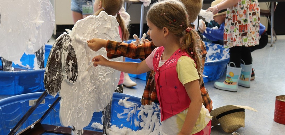 Students use shaving cream to simulate shearing a sheep.