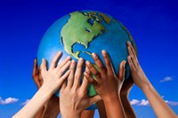 Children's hands holding up a globe